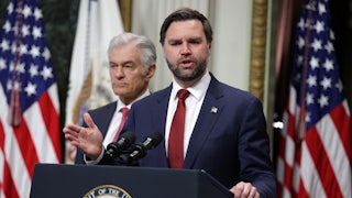 Vice President JD Vance gestures and speaks at a podium. Dr. Oz stands behind him