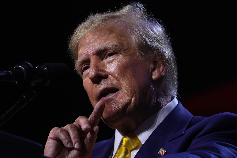 Donald Trump holds his finger up to his mouth