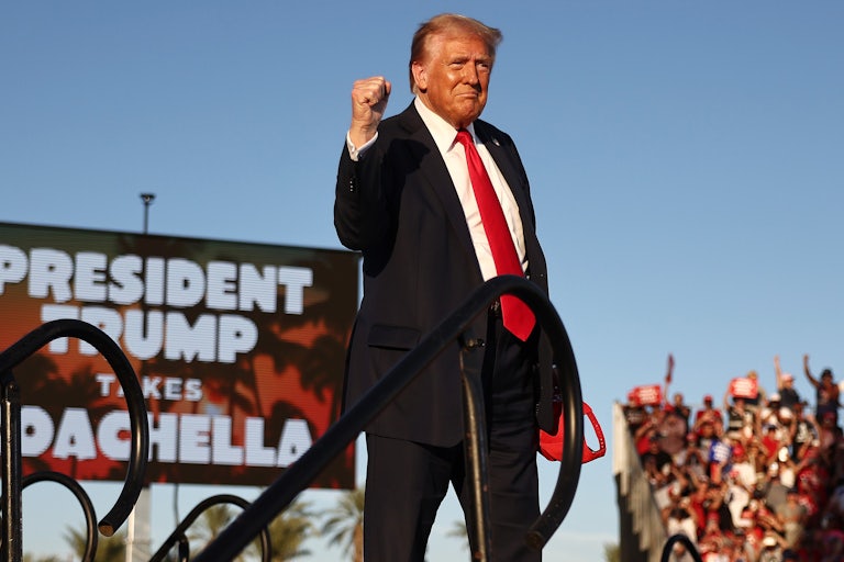 Donald Trump pumps his fist while walking on stage at his rally in Coachella, California