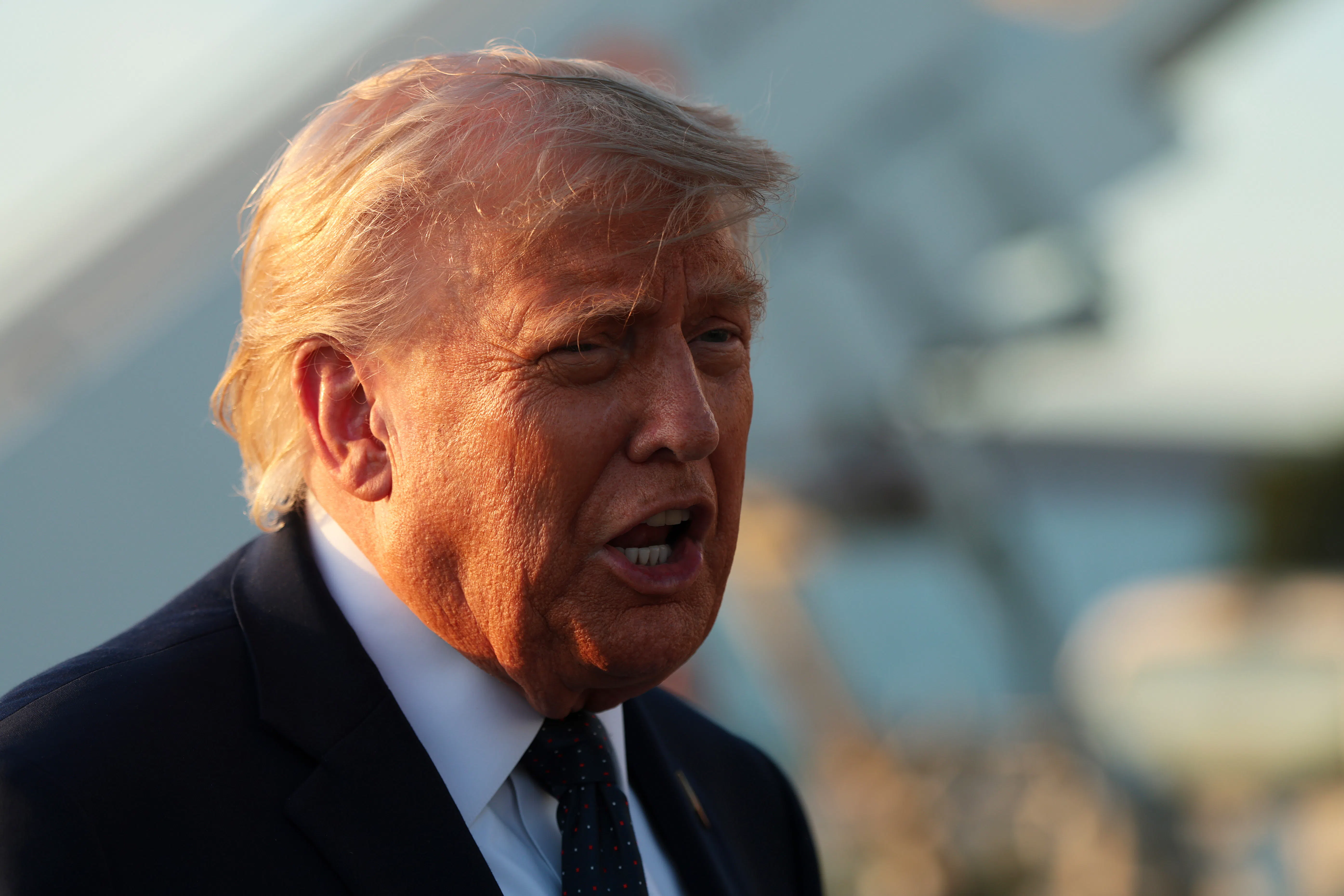A close-up of President Trump from the side, mid-speech