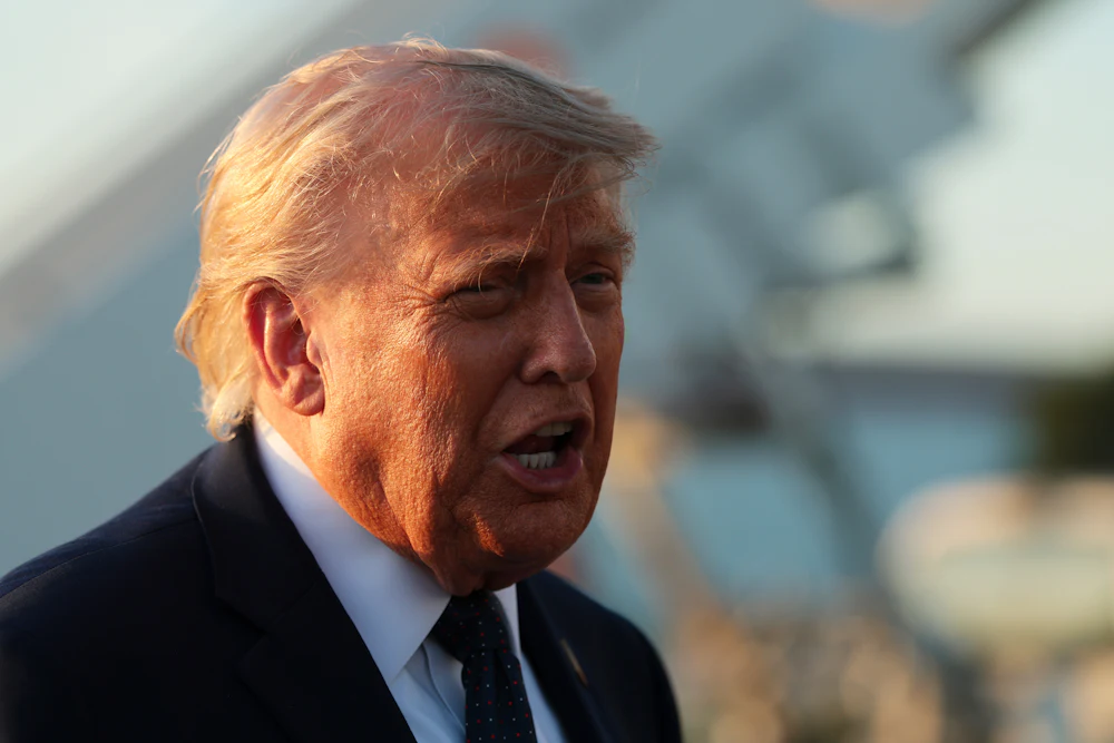 A close-up of President Trump from the side, mid-speech