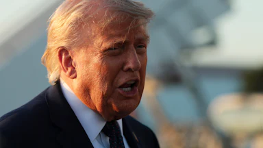 A close-up of President Trump from the side, mid-speech