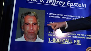 A finger points to Jeffrey Epstein's face on a poster that reads U.S. v Jeffrey Epstein, and lists facts about the case.