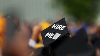 Commencement cap says "hire me"