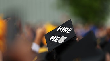 Commencement cap says "hire me"
