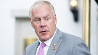 Representative Ryan Zinke turns his head to the side while walking