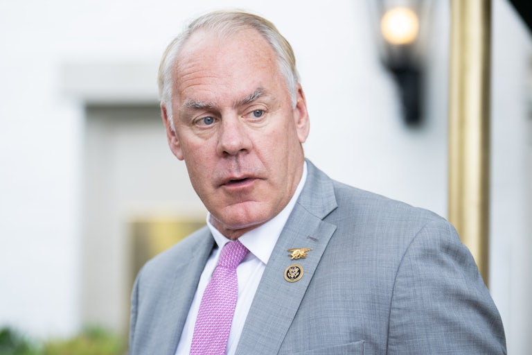 Representative Ryan Zinke turns his head to the side while walking