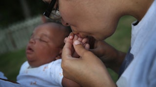 Woman kisses baby's hand