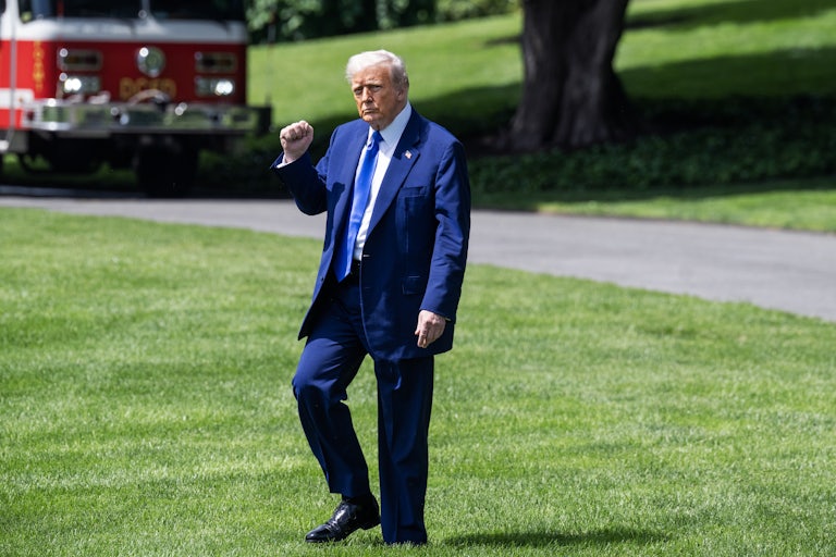 Donald Trump raises a fist while walking outside the White House