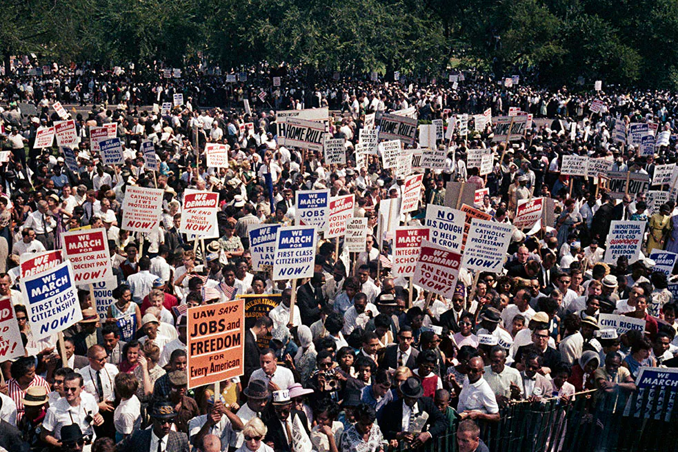 Thousands of diverse demonstrators fill the National Mall carrying 'Jobs and Freedom' signs at the 1963 March on Washington
