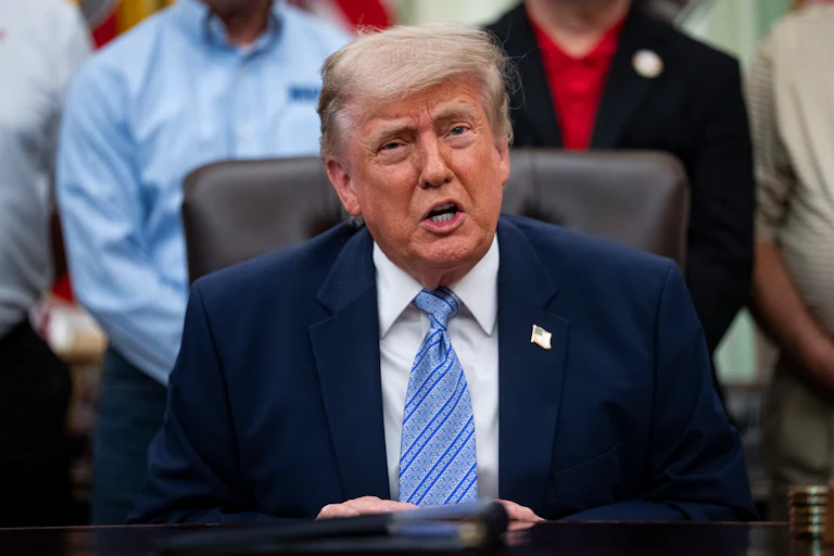 Donald Trump speaks while sitting at his desk in the Oval Office