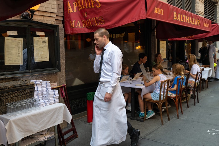 A waiter walks among tables at a New York City restaurant.