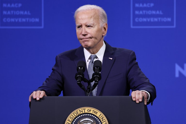 Joe Biden frowns as he stands at a podium during an NAACP event