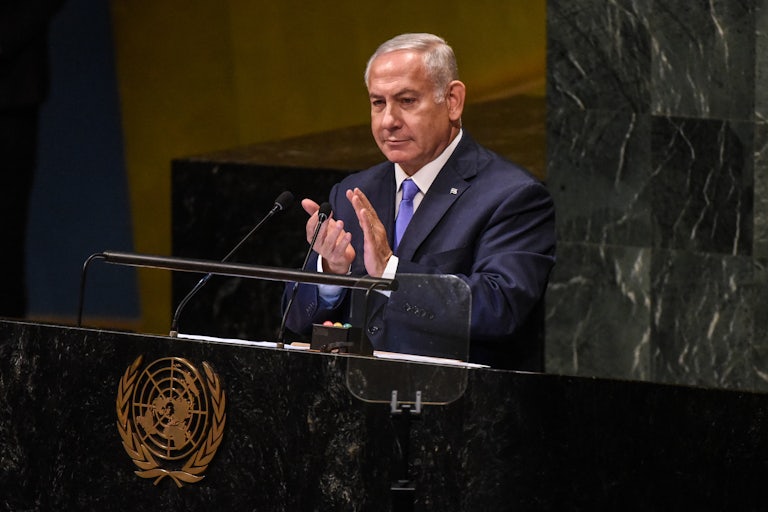Israeli Prime Minister Benjamin Netanyahu claps at the podium at the United Nations
