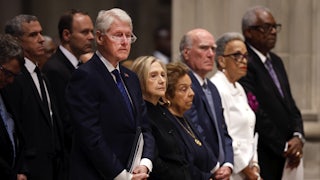 Former U.S. President Bill Clinton and former U.S. Secretary of State Hillary Clinton stand in a pew alongside others.
