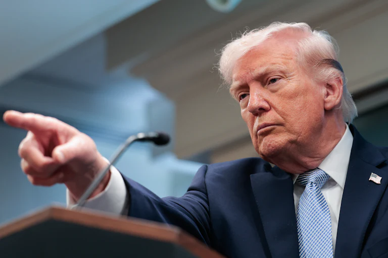 Donald Trump points while standing at a podium