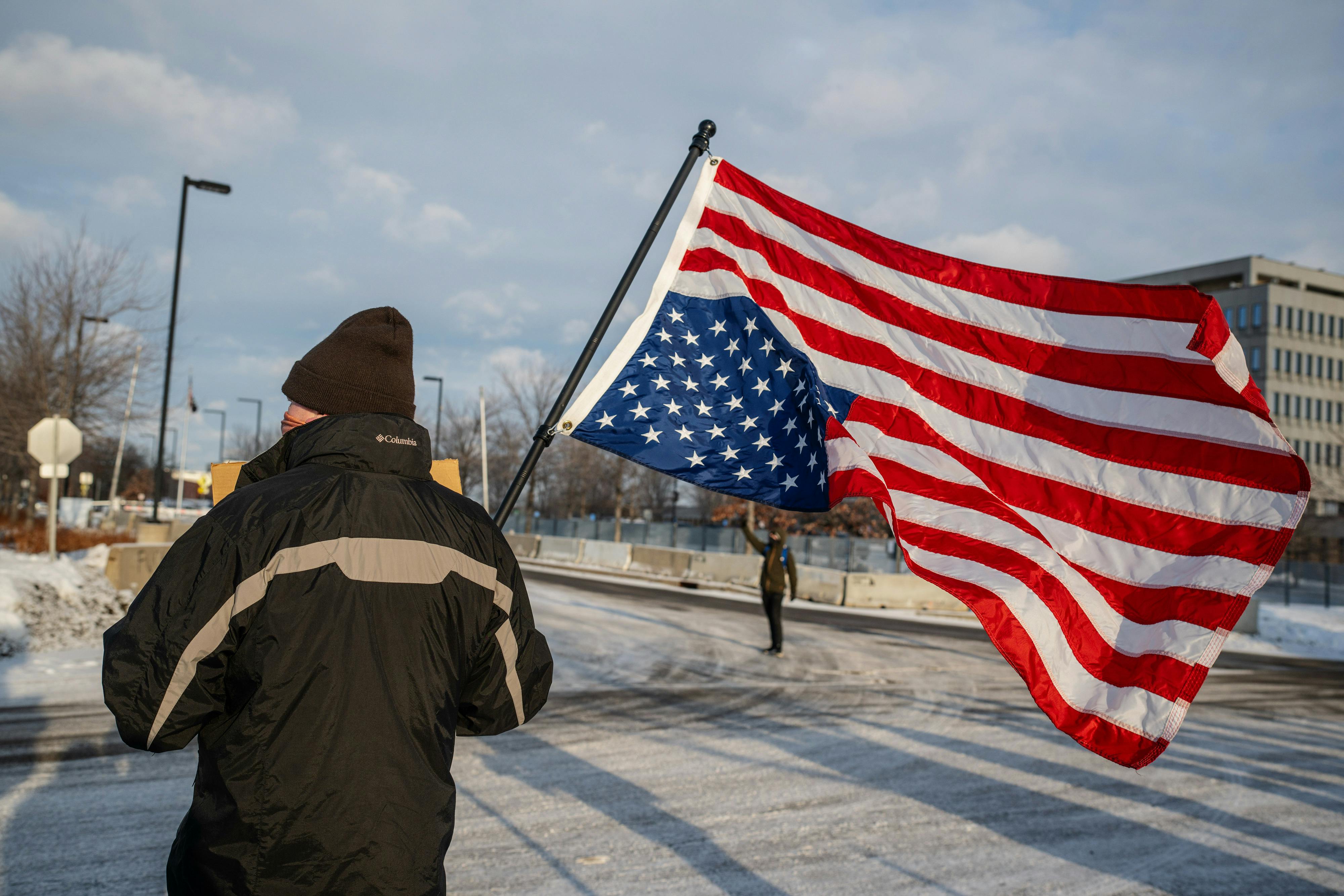 A demonstrator holds an upside-down US flag outside the Bishop Henry Whipple Federal Building in St. Paul, Minnesota.