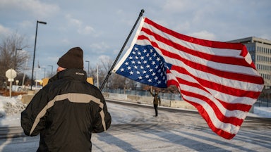 A demonstrator holds an upside-down US flag outside the Bishop Henry Whipple Federal Building in St. Paul, Minnesota.
