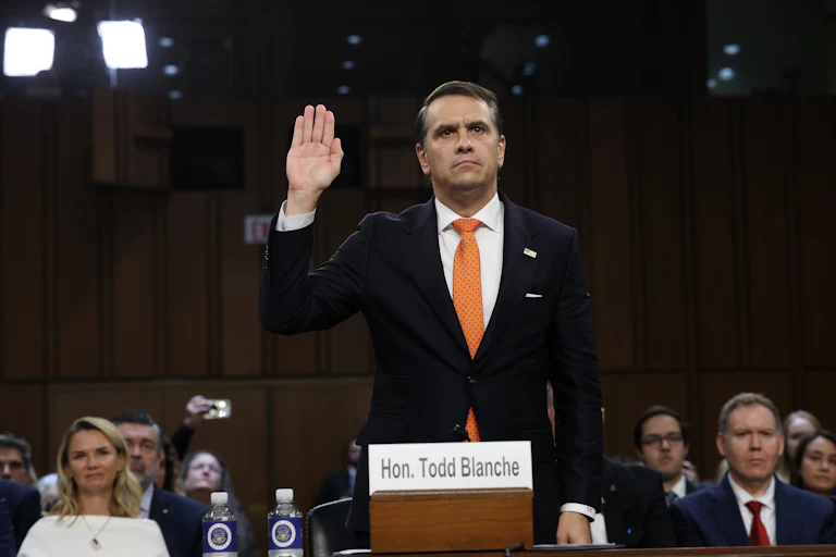 Acting Attorney General Todd Blanche holds his hand up as he's sworn in to his confirmation hearing in the Senate Judiciary Commitee