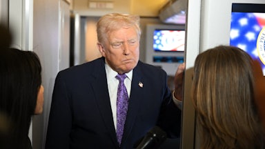 Donald Trump frowns while standing in front of reporters on Air Force One