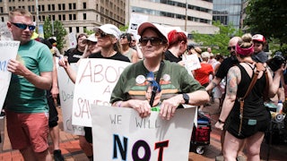 A protester holds a placard that reads "We will not go back" in support of abortion rights, Dayton, Ohio, May 2022. Other protesters stand nearby.