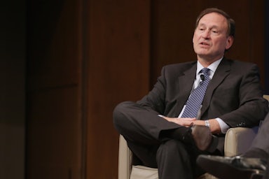 Supreme Court Justice Samuel Alito reclines in a chair.