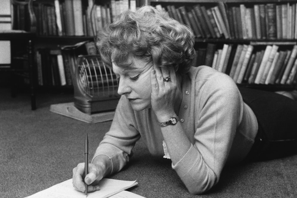 Muriel Spark lying on the floor, writing, in 1960