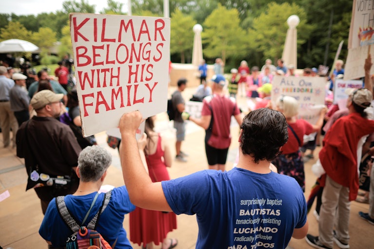 A person holds up a sign that says, "Kilmar belongs with his family" at a protest in support of Kilmar Abrego Garcia outside a courthouse in Greenbelt, Maryland