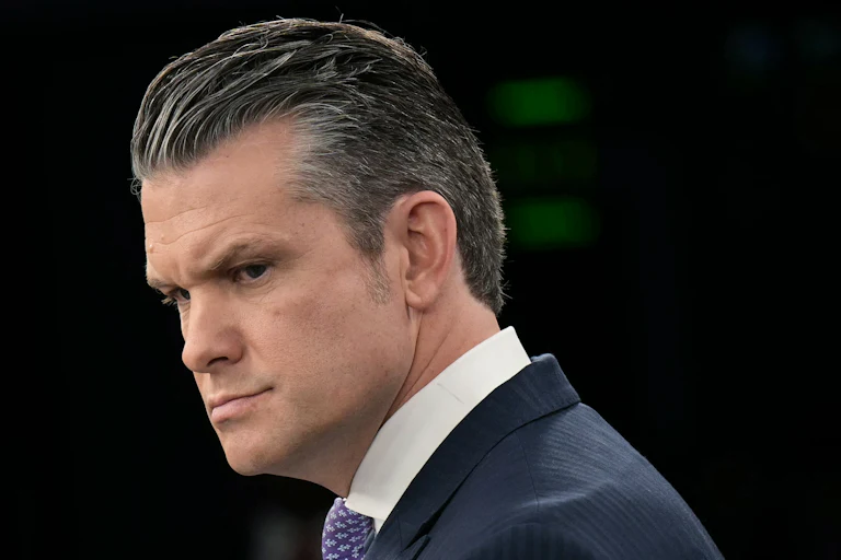 Defense Secretary Pete Hegseth frowns and looks to the side during a press conference