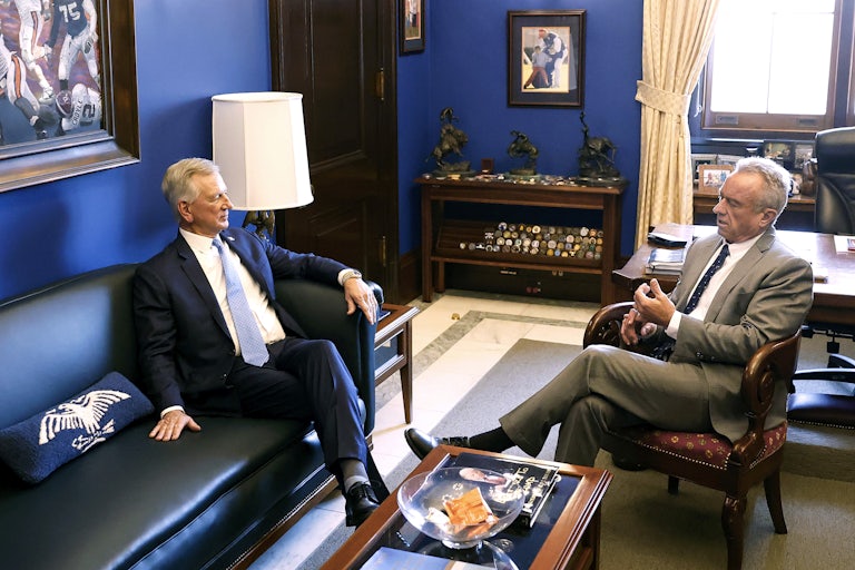 Tommy Tuberville and Robert F. Kennedy Jr. sit opposite each other and talk