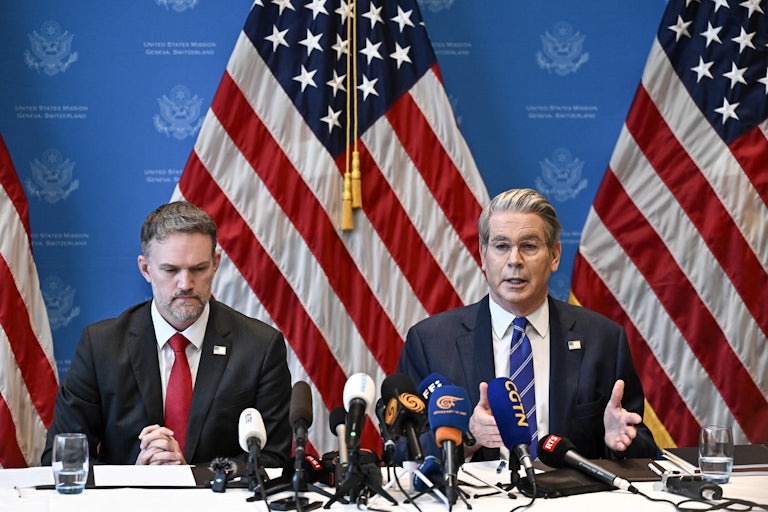 Trade Representative Jamieson Greer and Treasury Secretary Scott Bessent sit next to each other at a table covered with microphones