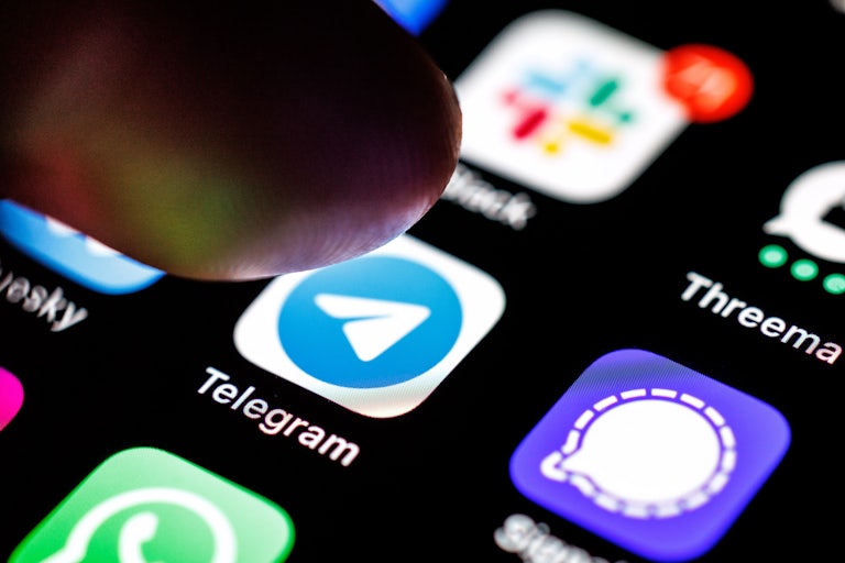 A finger hovers over the Telegram app on a smart phone.