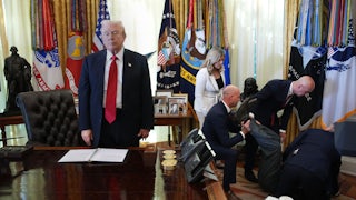 Donald Trump stands at his desk in the Oval Office while people help Gordon Findlay, a Novo Nordisk executive who collapsed