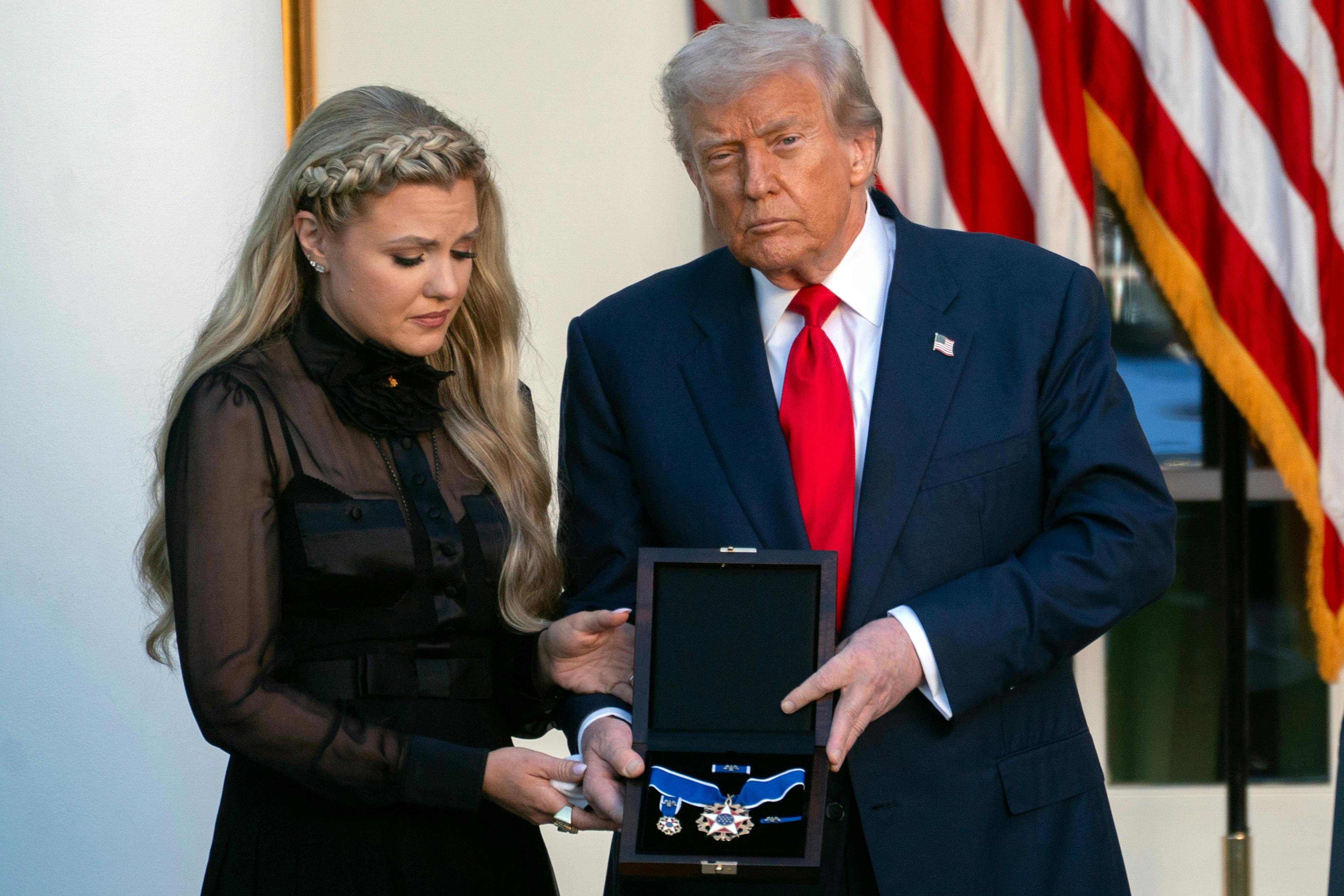 Donald Trump stands in the White House Rose Garden and presents a Presidential Medal of Freedom to Charlie Kirk's widow Erika