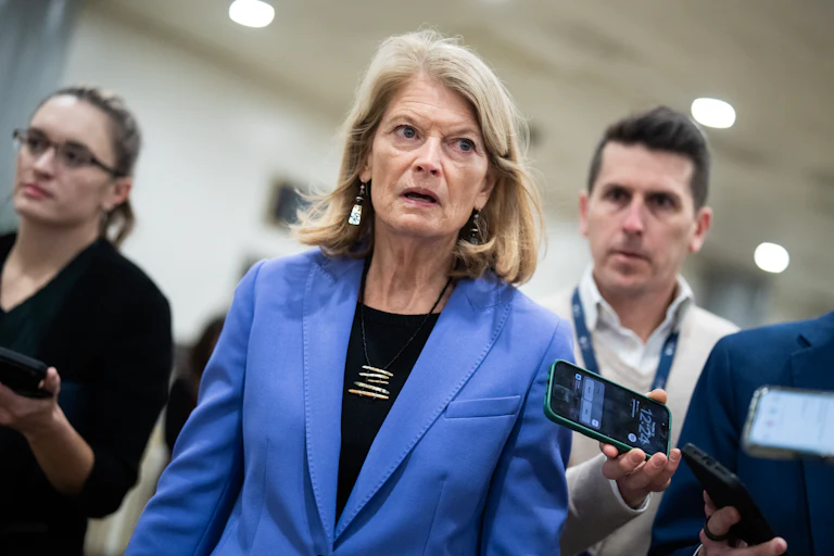 Senator Lisa Murkowski walks in the Capitol as reporters surround her
