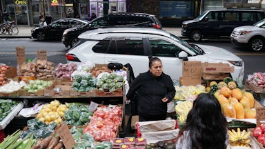 A woman sells produce on a street in the Queens in November of 2019.