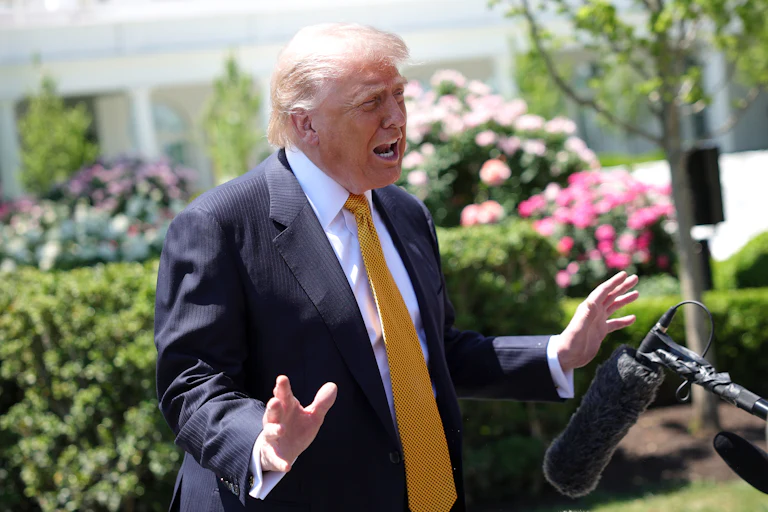 Donald Trump gestures while speaking to reporters outside the White House