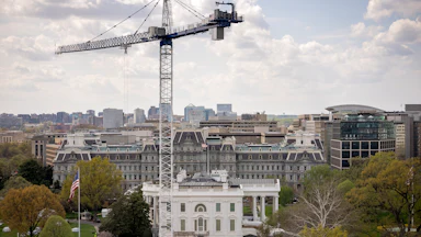A crane stands next to the White House