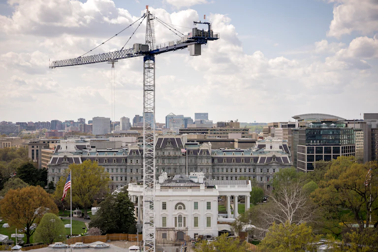 A crane stands next to the White House