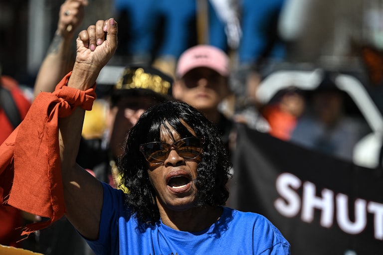 A demonstrator holds up a fist as others stand in the background.