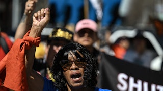 A demonstrator holds up a fist as others stand in the background.