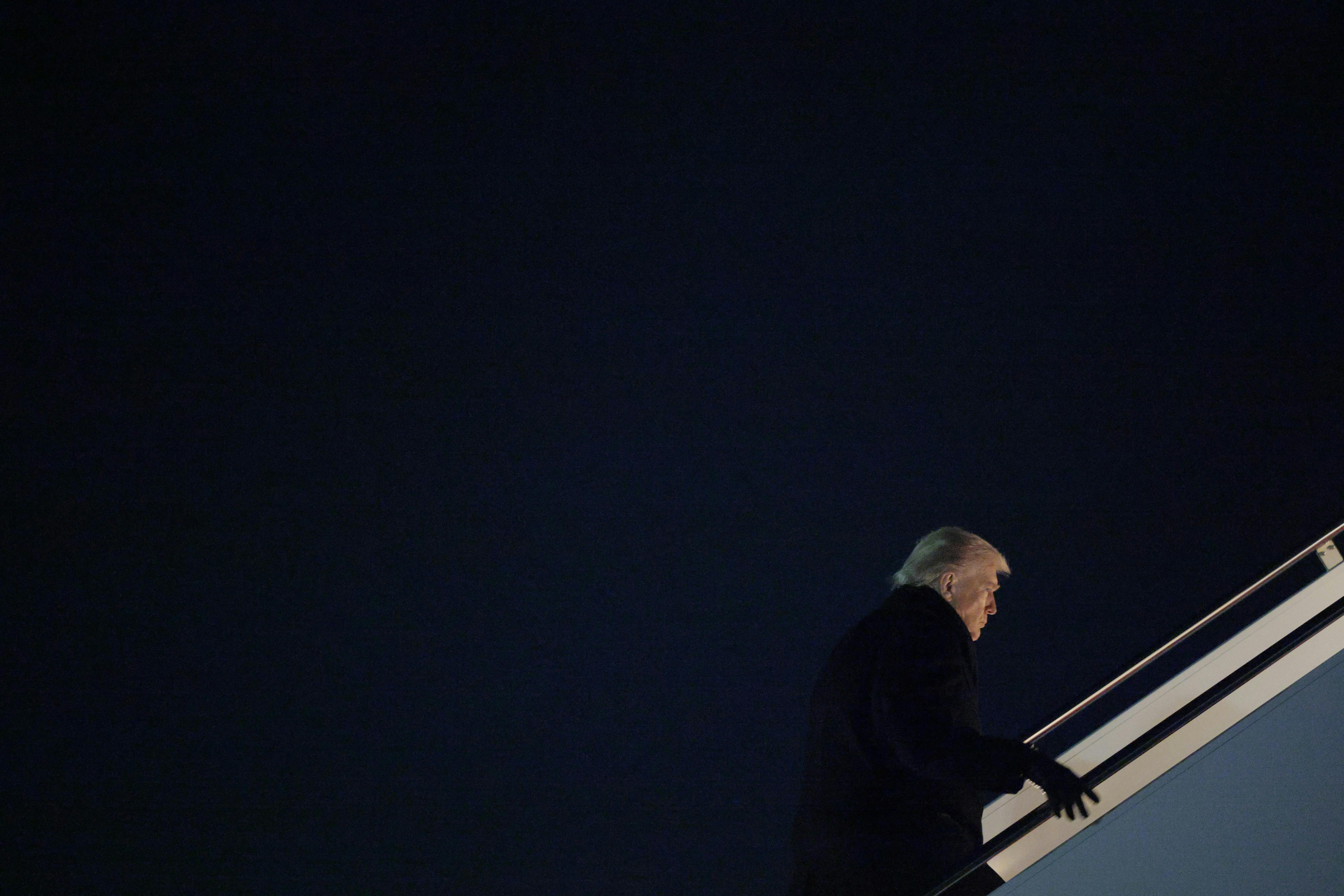 Donald Trump walks up the stairs to board Air Force One