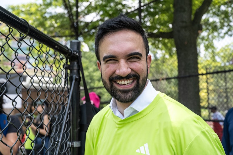 Zohran Mamdani smiles outside