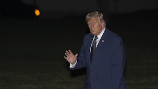 Donald Trump waves while walking outside the White House