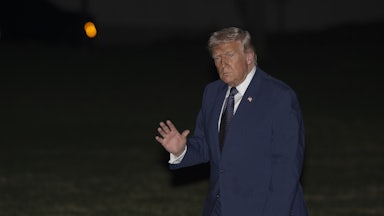 Donald Trump waves while walking outside the White House