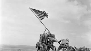 Six U.S. Marines raise an American flag atop Mount Suribachi on Iwo Jima during World War II.