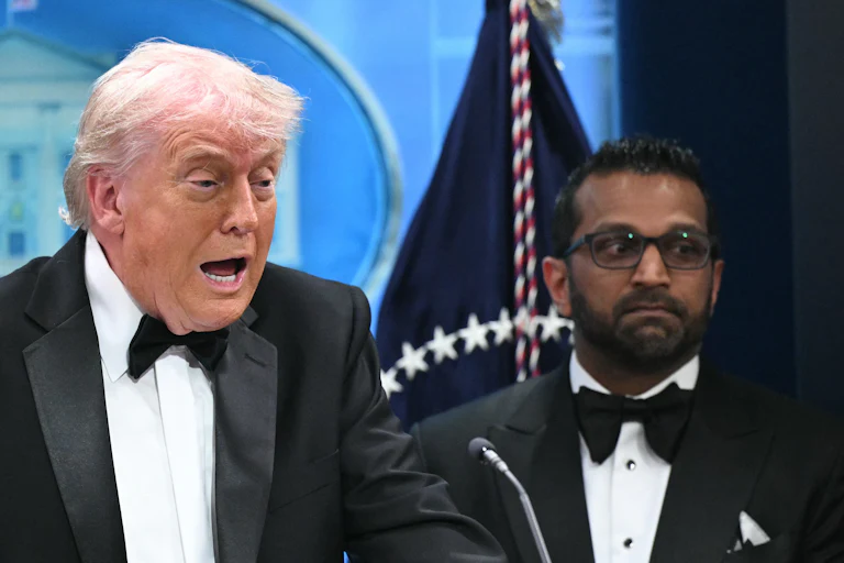 Donald Trump speaks, while Kash Patel stands behind him