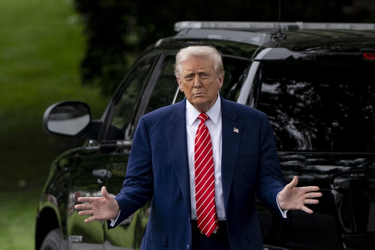 Donald Trump holds his hands out to the side while walking outside the White House
