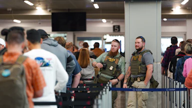 ICE agents stand next to a security line at Hartsfield-Jackson Atlanta International Airport