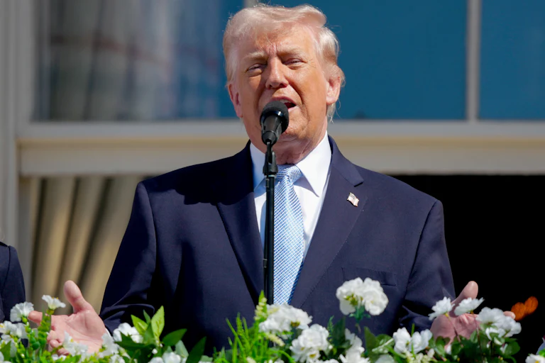 Donald Trump gestures while speaking from the White House balcony